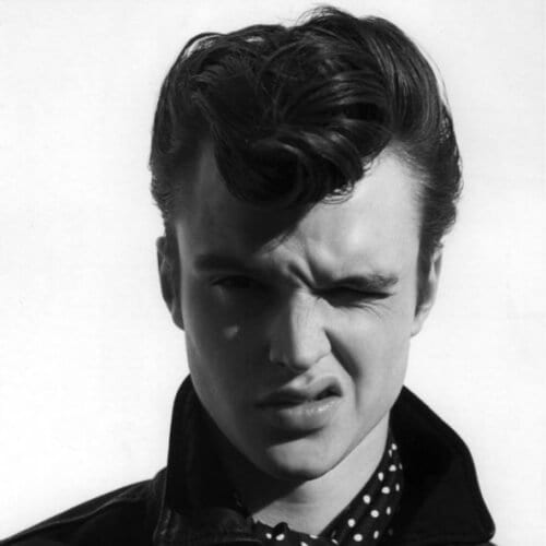 Front Curl Pomp - a man winking and is wearing a polka dotted polo