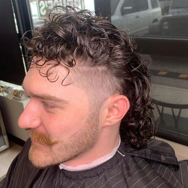 Beautiful Perm with Blonde Mustache Mullet - a man wearing striped barber cape.