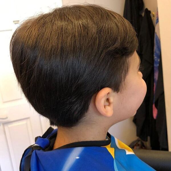 Classic Hairstyle - a boy wearing a barber cape.