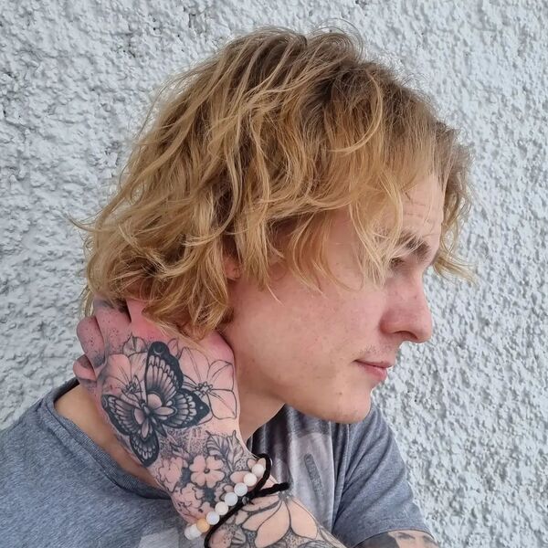 Cool Blonde Curtain Bob - a man wearing beads bracelet with hand tattoo.