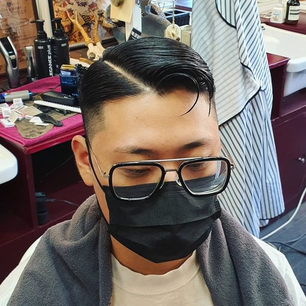 Diagonal Side Part Haircut - a man wearing glasses with facemask.