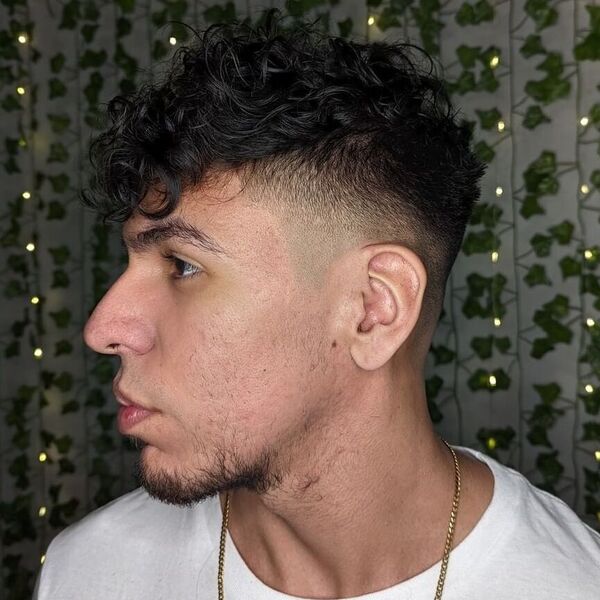 Fade Undercut with Tiny Beach Curls - a man wearing gold necklace in plain white shirt.