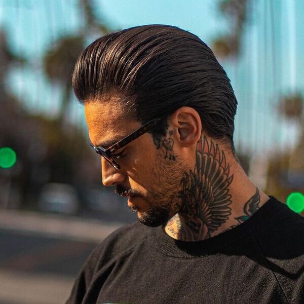 Fine Layered Ducktail Haircut - a man wearing glasses and black shirt.