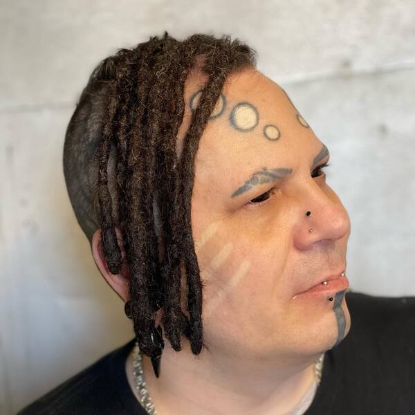Front Mohawk in Crochet Dreads - a man with face and eyes tattoo.
