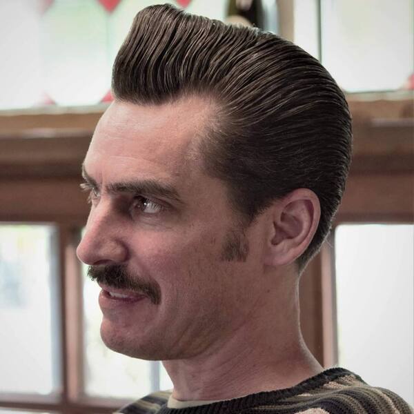 Layered Pompadour Ducktail Haircut - a man wearing a knitted sweater.