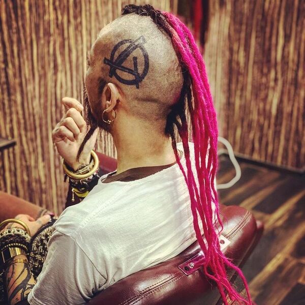 Mohawk with Pink Tinted Long Dreads - a man wearing a lot of wrist accessories and also wearing plain whited shirt.