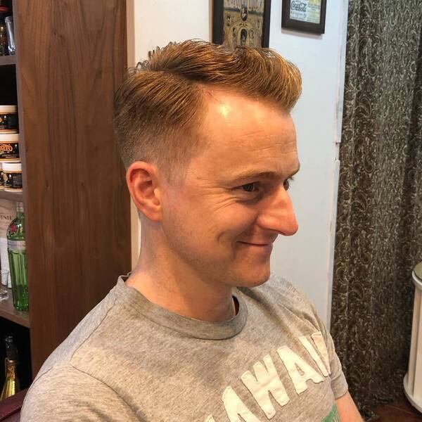 Regent Side Part Haircut - a man wearing a gray printed shirt.