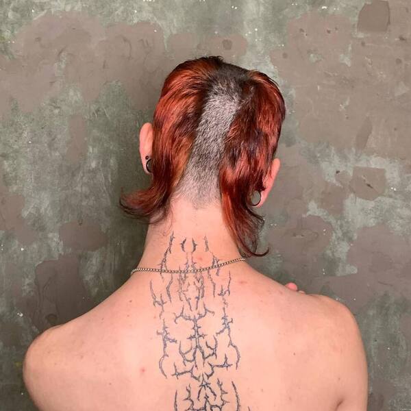 Reverse Mohawk - a man with back tattoo.
