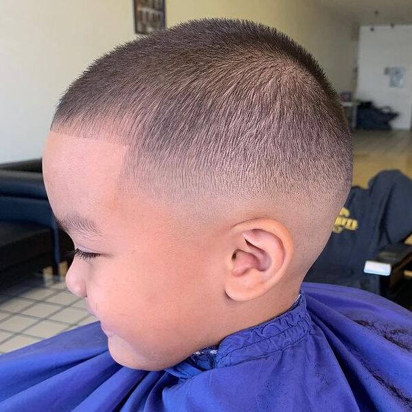 Semi-Bald Cut - a little boy wearing a barber cape.