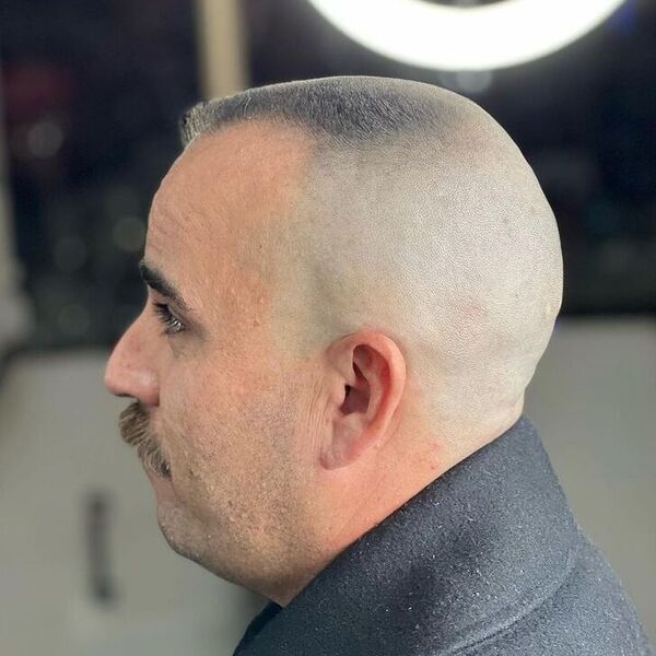 Short Spiky Shaved Hairstyles for Balding Crowns - a man wearing a black coat.