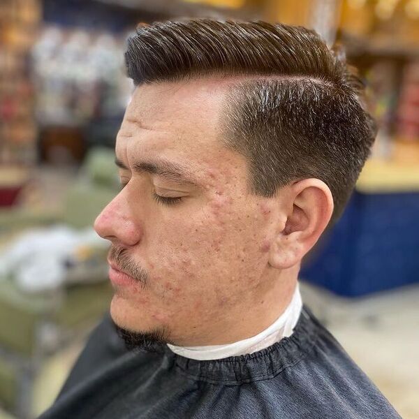 Side Part Blowout Fade Haircut - a man wearing black cape.