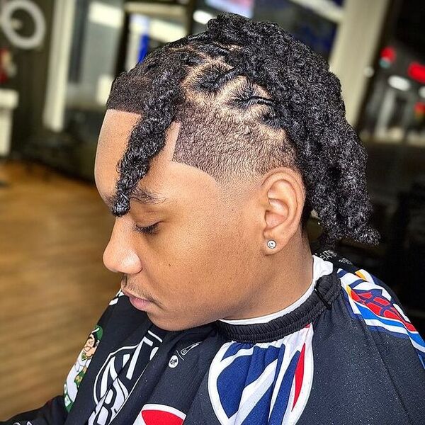 South of France Haircut in Box Braid Dreads - a man wearing printed barber cape.