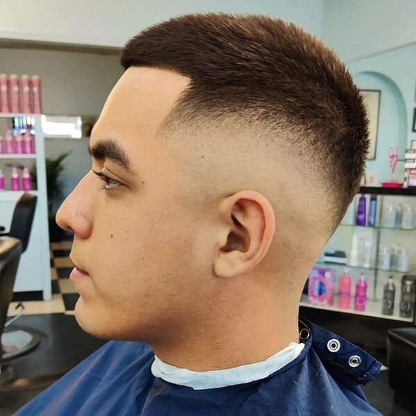 Classic Low Fade for Men - a man wearing a blue barber cape