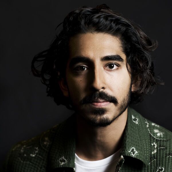 Dev Patel's Curly Celebrity Hairstyles for Men- Dev Patel is wearing printed green polo.