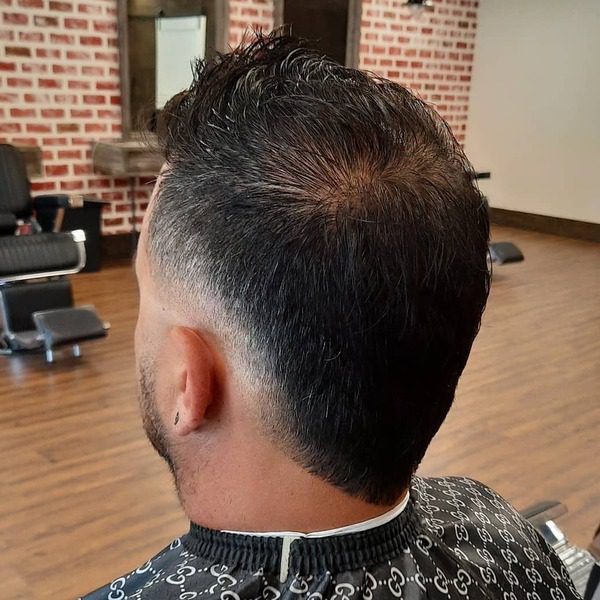 Faux Mohawk Haircut - a man wearing Gucci print inspired barber cape.