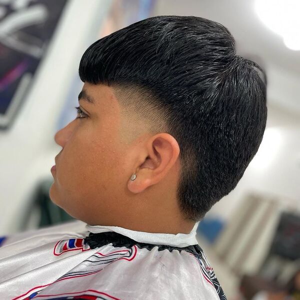 Fine Fringe Mexican Mullet - a man wearing earring and printed barber cape.