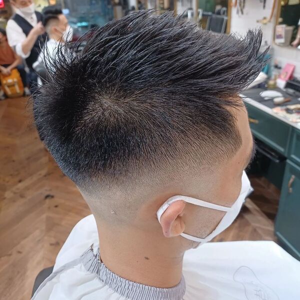Long Spiky Crew Taper Fade - a man wearing white mask in barber cape.