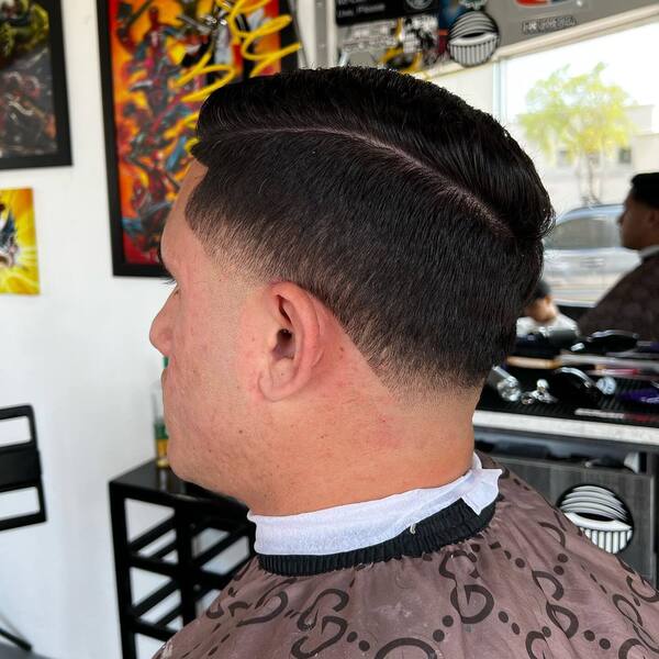 Low Fade Comb Over- a man wearing a brown barber's cape