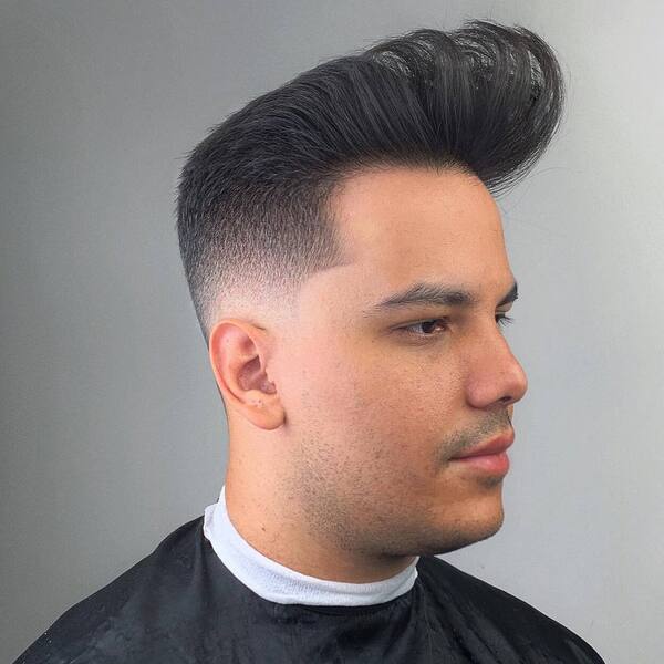 Modern High Pompadour Fades White Boy Haircuts - a man wearing black barber cape.