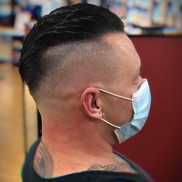 Classic Faded Side Haircut with Fury Style - a man with a tattoo