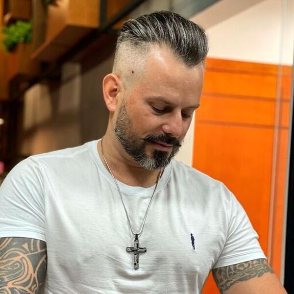 Skin Faded Haircut with Fury Hairstyle - a man wearing a necklace with a cross sign pendant