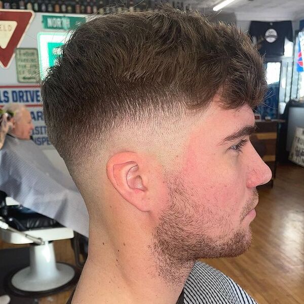 Skin Low Fade Wavy Haircut with Regular Hairstyle - a man wearing a stripped cover