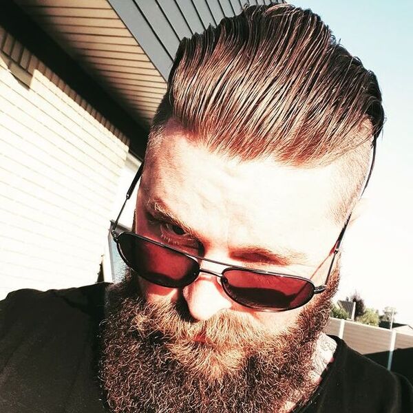 Slicked Clean Side Fade with Fury Hairstyle - a man wearing an sunglasses