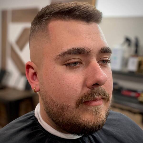 wearing gold round earring and black haircut cover