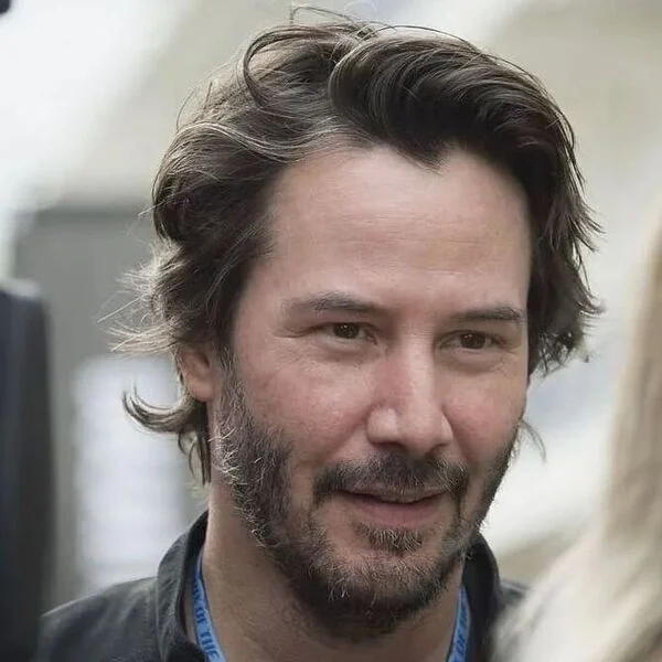 Keanu Reeves Hairstyle Side Slicked Hairstyle with Wavy Style - wearing jacket with blue lanyard