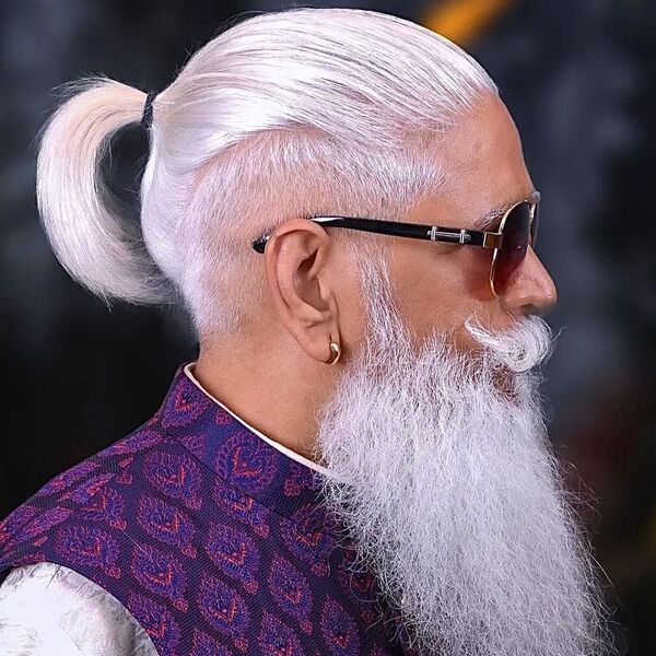 A man wearing sunglass with gold earring and ponytail hairstyles for men