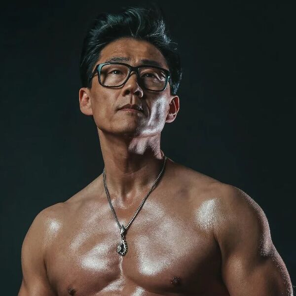A man that is shirtless and wearing silver necklace